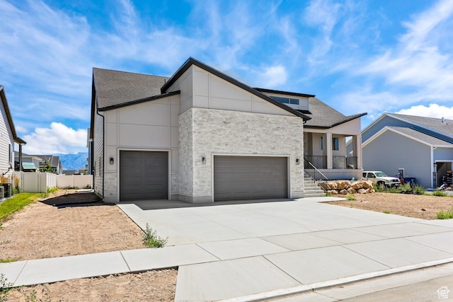 1107 S 4475 W, West Point, UT 84015 - contemporary home with stone siding, concrete driveway, an attached garage, covered porch, and roof with shingles