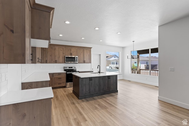 1107 S 4475 W, West Point, UT 84015 - kitchen featuring appliances with stainless steel finishes, tasteful backsplash, light countertops, light wood finished floors, and recessed lighting