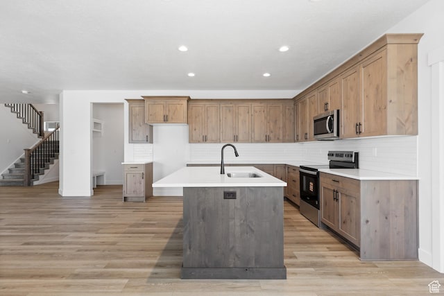 1107 S 4475 W, West Point, UT 84015 - kitchen featuring appliances with stainless steel finishes, a kitchen island with sink, recessed lighting, decorative backsplash, and light wood-type flooring