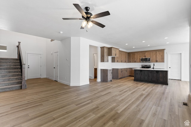 1107 S 4475 W, West Point, UT 84015 - unfurnished living room featuring a ceiling fan, stairs, recessed lighting, and light wood-style flooring