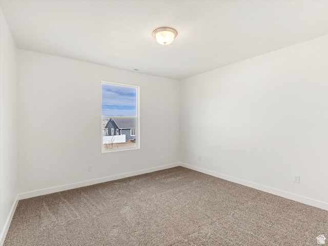 carpeted spare room with baseboards