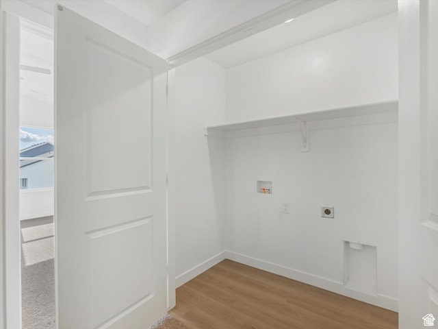 clothes washing area featuring laundry area, light wood-style flooring, hookup for an electric dryer, washer hookup, and baseboards
