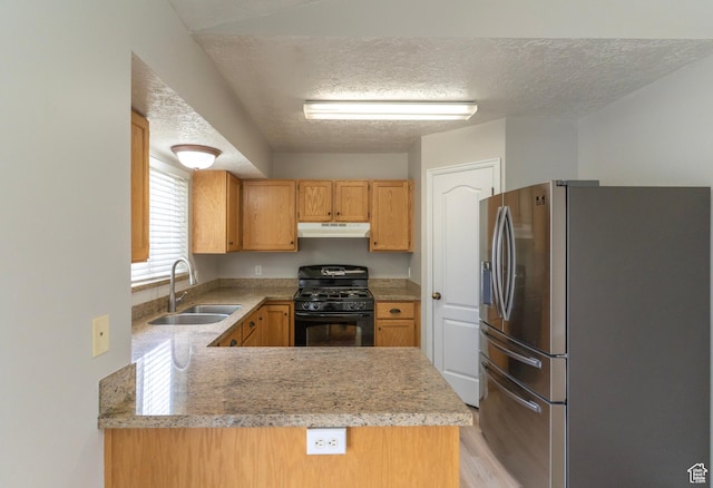 1608 W 8470 S, West Jordan, UT 84088 - kitchen with under cabinet range hood, light countertops, black gas range oven, a sink, and stainless steel refrigerator with ice dispenser