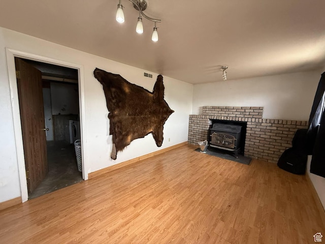 35 E 970 N, Castle Dale, UT 84513 - unfurnished living room with a wood stove, visible vents, wood finished floors, and washer / clothes dryer