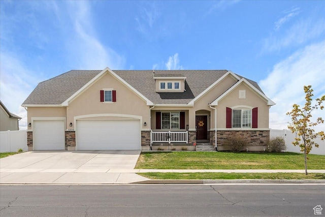 craftsman-style home featuring a porch, a front lawn, stone siding, and stucco siding