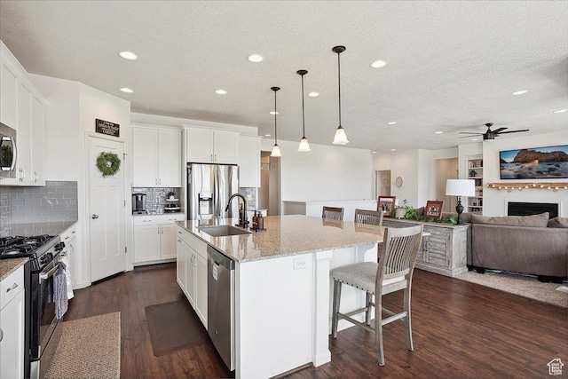3339 W 650 N, Layton, UT 84041 - kitchen featuring recessed lighting, a sink, dark wood-style flooring, a breakfast bar area, and appliances with stainless steel finishes