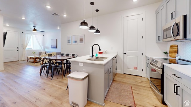 5399 S Cerulean Ln Unit 98, St George, UT 84790 - kitchen featuring light wood-style flooring, appliances with stainless steel finishes, a sink, pendant lighting, and a peninsula