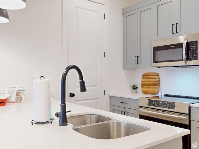 5399 S Cerulean Ln Unit 98, St George, UT 84790 - kitchen with tasteful backsplash, a sink, stainless steel appliances, light countertops, and gray cabinets