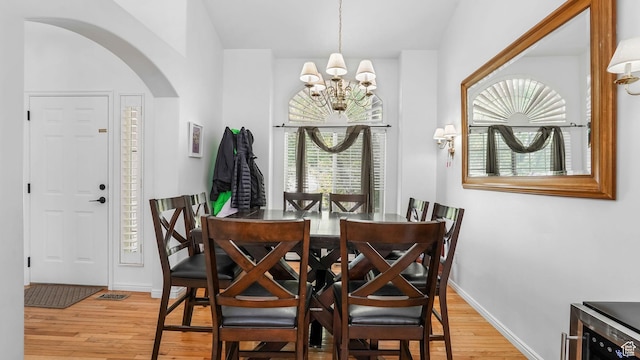 450 E Waterford Way, Midvale, UT 84047 - dining space with beverage cooler, arched walkways, an inviting chandelier, light wood finished floors, and baseboards