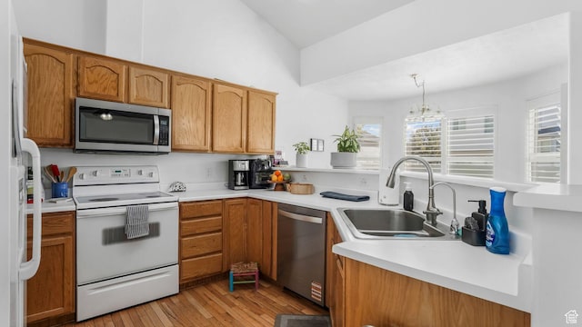 450 E Waterford Way, Midvale, UT 84047 - kitchen with light wood-style flooring, appliances with stainless steel finishes, light countertops, a sink, and a peninsula