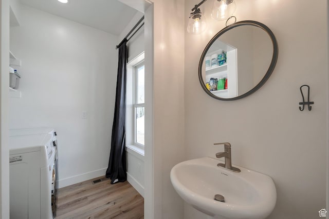 4460 Fawn Way Unit 2039, Heber City, UT 84032 - bathroom featuring a sink, wood finished floors, a healthy amount of sunlight, and washing machine and clothes dryer