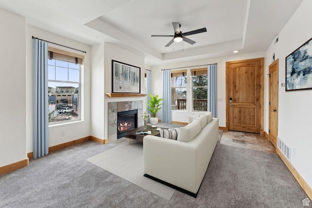1541 Redstone Ave Unit C, Park City, UT 84098 - carpeted living area featuring a tiled fireplace, a ceiling fan, a tray ceiling, and a wealth of natural light