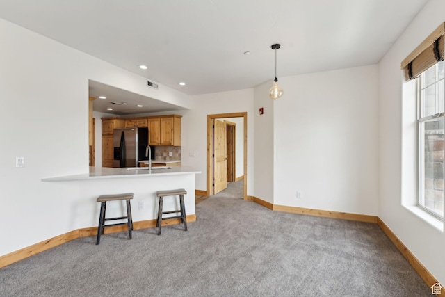 1541 Redstone Ave Unit C, Park City, UT 84098 - kitchen featuring a breakfast bar, stainless steel fridge, a sink, light carpet, and light countertops