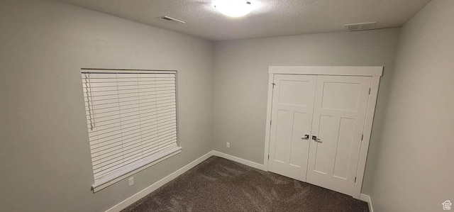 1016 N Vista Loop, Morgan, UT 84050 - unfurnished bedroom with a textured ceiling, visible vents, baseboards, and dark colored carpet