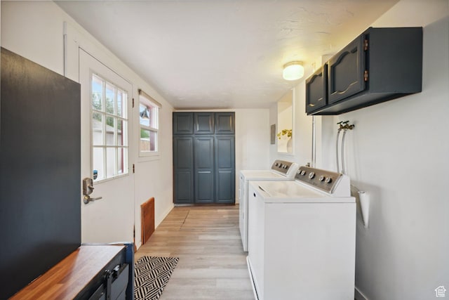 laundry area featuring light wood-style floors, baseboards, washing machine and dryer, and cabinet space