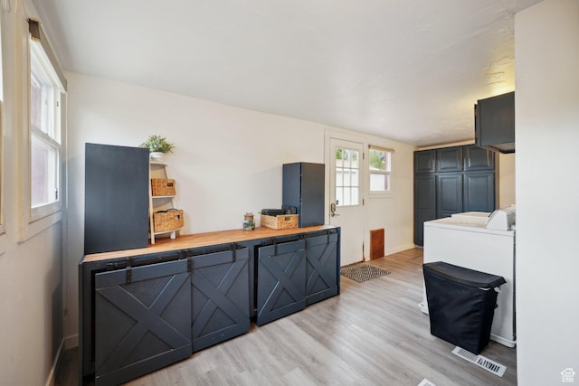 interior space featuring visible vents, light wood finished floors, and baseboards