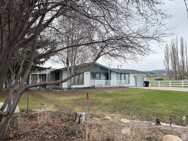1705 S Bear Lake Blvd, Garden City, UT 84028 - view of front of house featuring covered porch, fence, and a front lawn