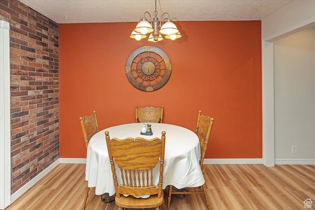 33 S Benchview Dr E, Tooele, UT 84074 - dining area with an accent wall, wood finished floors, brick wall, baseboards, and a chandelier