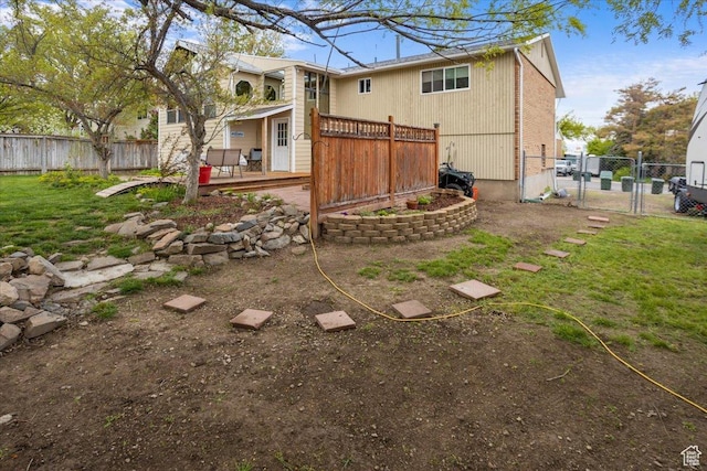 33 S Benchview Dr E, Tooele, UT 84074 - view of yard featuring fence, a wooden deck, and a gate