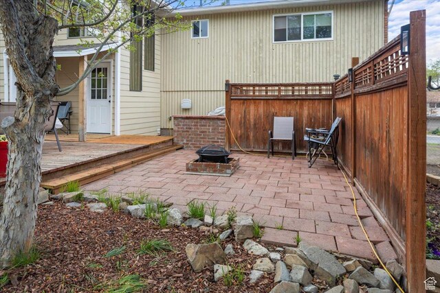 33 S Benchview Dr E, Tooele, UT 84074 - view of patio with a fire pit, fence, and a wooden deck