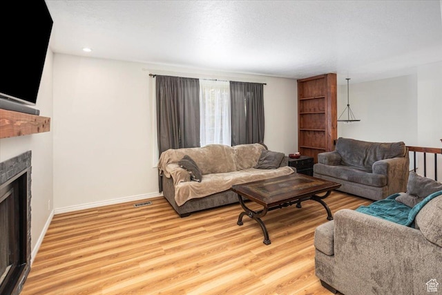 33 S Benchview Dr E, Tooele, UT 84074 - living room with a fireplace, light wood-style flooring, recessed lighting, baseboards, and visible vents