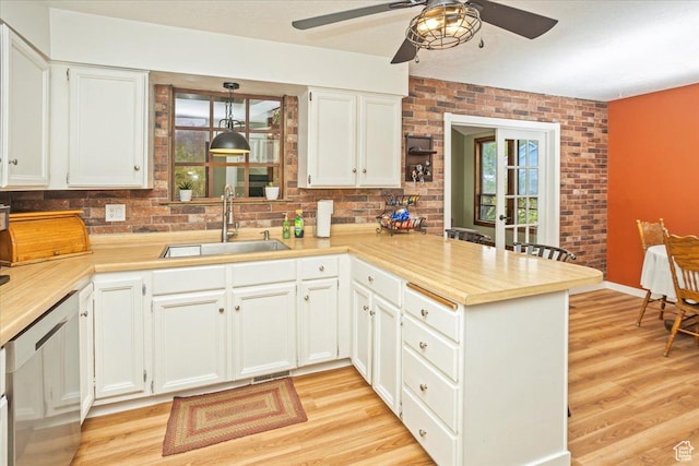 33 S Benchview Dr E, Tooele, UT 84074 - kitchen featuring a sink, a peninsula, light wood-style floors, light countertops, and a ceiling fan