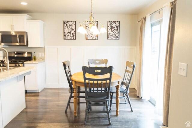 5229 W Armada Way, Herriman, UT 84096 - dining space featuring an inviting chandelier, a decorative wall, and dark wood-style floors