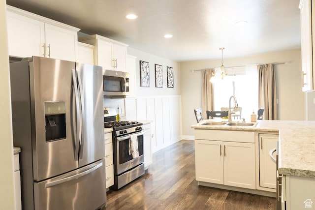 5229 W Armada Way, Herriman, UT 84096 - kitchen with wainscoting, a sink, light countertops, stainless steel appliances, and dark wood-style floors