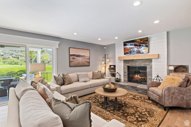 living area with recessed lighting, wood finished floors, and a fireplace