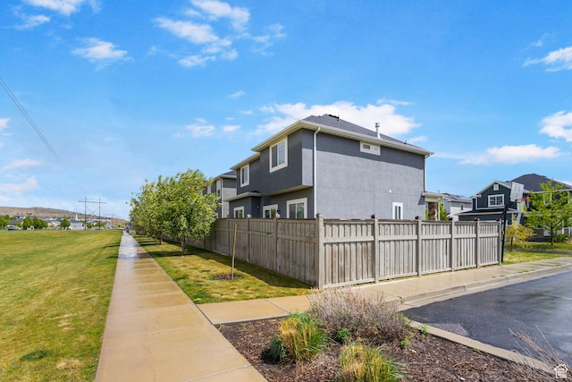 7465 N Cottage Ln, Eagle Mountain, UT 84005 - view of property exterior with fence, stucco siding, a yard, and a residential view