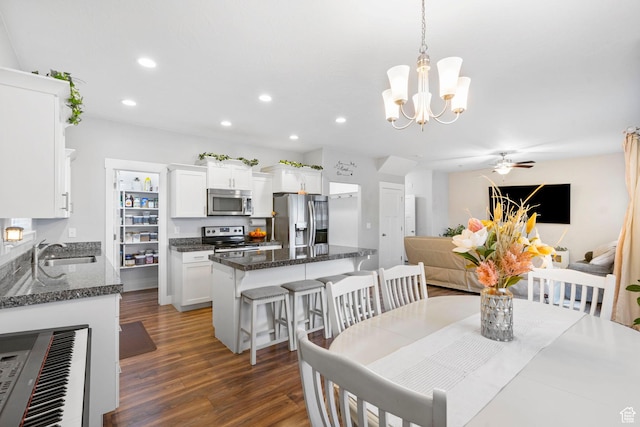 7465 N Cottage Ln, Eagle Mountain, UT 84005 - dining space featuring dark wood-type flooring, recessed lighting, and ceiling fan with notable chandelier
