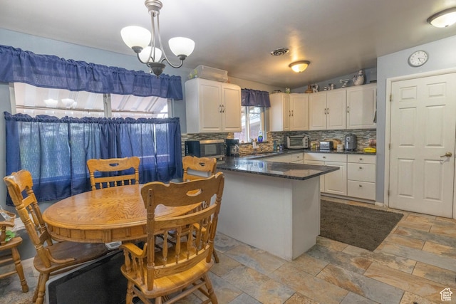 5393 S 700 E, South Ogden, UT 84405 - kitchen featuring white cabinets, stone tile floors, a peninsula, stainless steel microwave, and tasteful backsplash