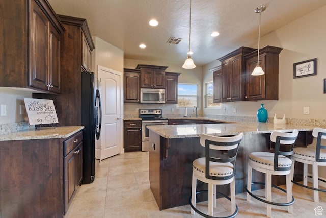 430 N 3450 W, Hurricane, UT 84737 - kitchen with appliances with stainless steel finishes, dark brown cabinetry, a peninsula, a sink, and a kitchen bar