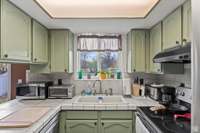 1554 S Monroe Blvd Unit F4, Ogden, UT 84404 - kitchen featuring range with electric stovetop, stainless steel microwave, under cabinet range hood, a sink, and green cabinets