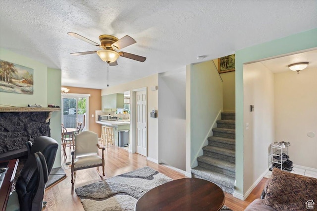 1554 S Monroe Blvd Unit F4, Ogden, UT 84404 - living room with light wood-style flooring, stairs, a textured ceiling, and ceiling fan