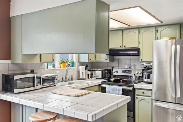 1554 S Monroe Blvd Unit F4, Ogden, UT 84404 - kitchen with under cabinet range hood, appliances with stainless steel finishes, and green cabinets