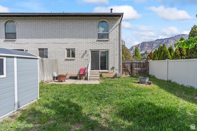 1554 S Monroe Blvd Unit F4, Ogden, UT 84404 - back of property featuring a yard, a mountain view, entry steps, and an outdoor fire pit