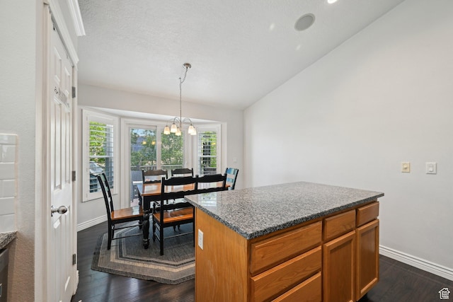 8551 S Laurel Oak Dr W, West Jordan, UT 84081 - kitchen with dark wood finished floors, brown cabinetry, a center island, baseboards, and vaulted ceiling