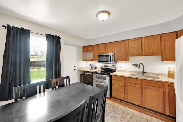 5756 S 4540 W, Kearns, UT 84118 - kitchen with appliances with stainless steel finishes, brown cabinetry, a sink, and light wood finished floors