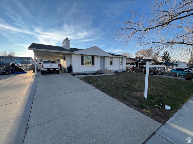 5676 S Wilderland Ln, Taylorsville, UT 84129 - single story home with driveway, a chimney, solar panels, a front yard, and an attached carport