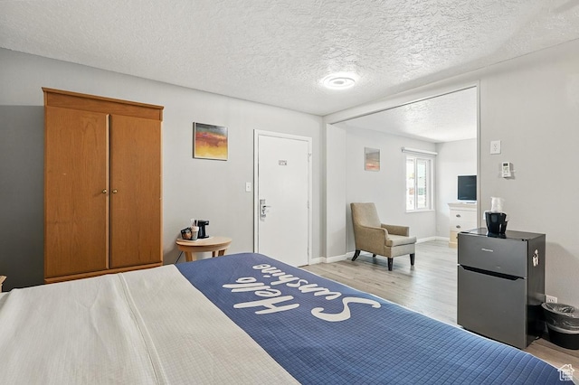 63 E Main, Bicknell, UT 84715 - bedroom featuring light wood-style floors, baseboards, and a textured ceiling