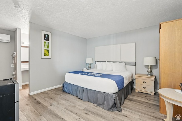 63 E Main, Bicknell, UT 84715 - bedroom featuring light wood-style floors, baseboards, an AC wall unit, and a textured ceiling