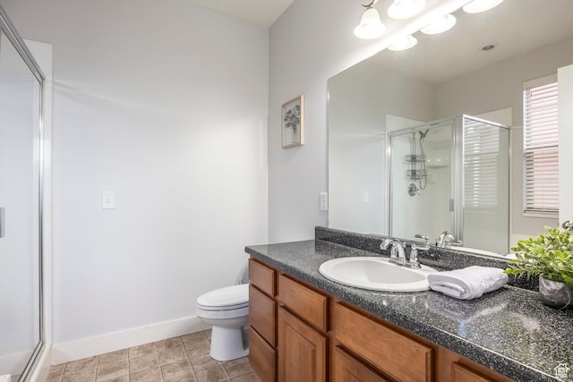 full bath featuring vanity, baseboards, a stall shower, and toilet