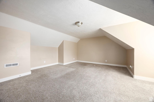bonus room featuring visible vents, carpet flooring, baseboards, and vaulted ceiling
