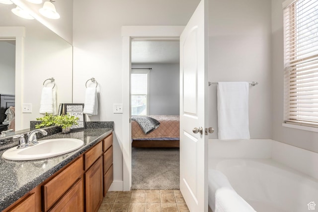 ensuite bathroom featuring vanity, ensuite bathroom, and a bath