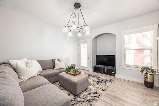 living room with baseboards, a wealth of natural light, wood finished floors, and visible vents