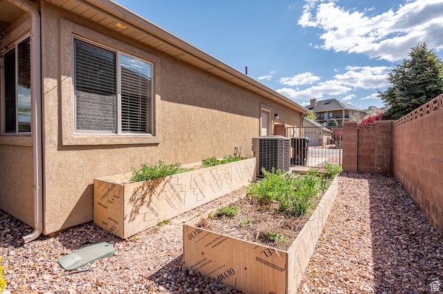 194 S 2875 W, Cedar City, UT 84720 - view of property exterior with fence, central AC unit, stucco siding, and a vegetable garden