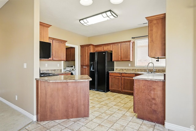 194 S 2875 W, Cedar City, UT 84720 - kitchen featuring a peninsula, baseboards, light countertops, a sink, and black fridge