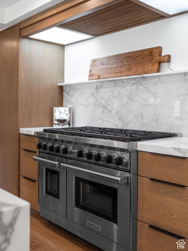 4554 N Forestdale Dr Unit A1, Park City, UT 84098 - kitchen with light countertops, brown cabinets, double oven range, and tasteful backsplash