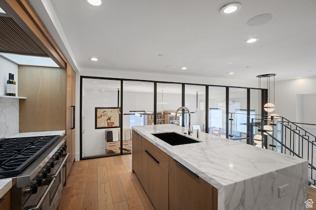 4554 N Forestdale Dr Unit A1, Park City, UT 84098 - kitchen featuring a kitchen island with sink, recessed lighting, a sink, light wood finished floors, and double oven range
